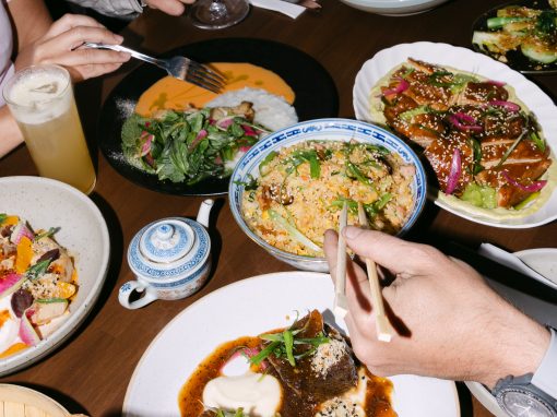 Kin + Folk table full of share plates with some hands reaching for various plates