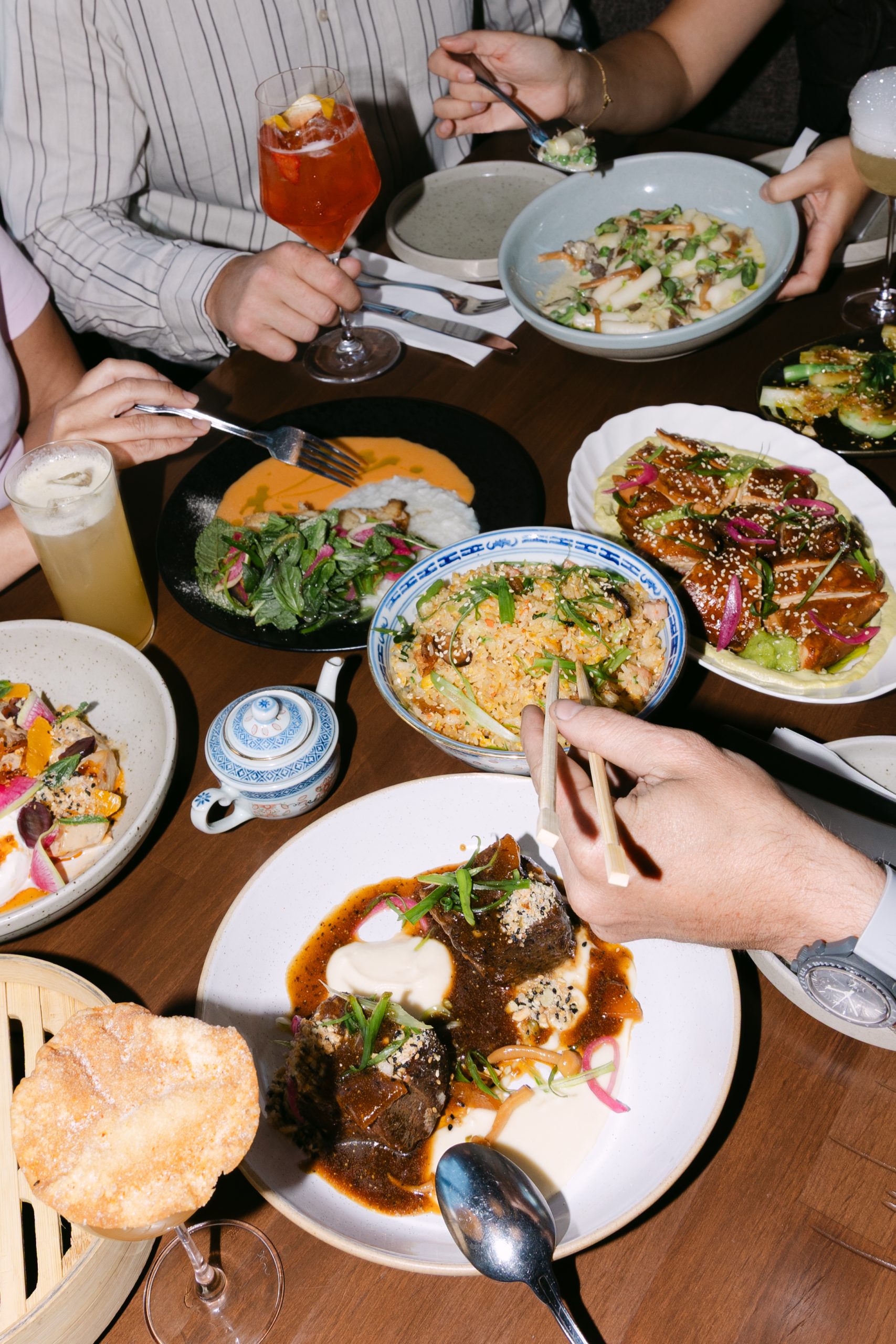 Kin + Folk table full of share plates with some hands reaching for various plates
