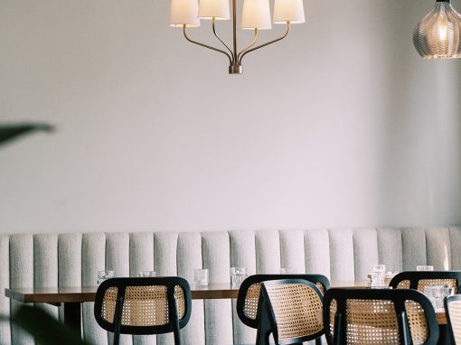 Kin + Folk bench seating with additional chairs and empty tables showcasing the beautiful modern space