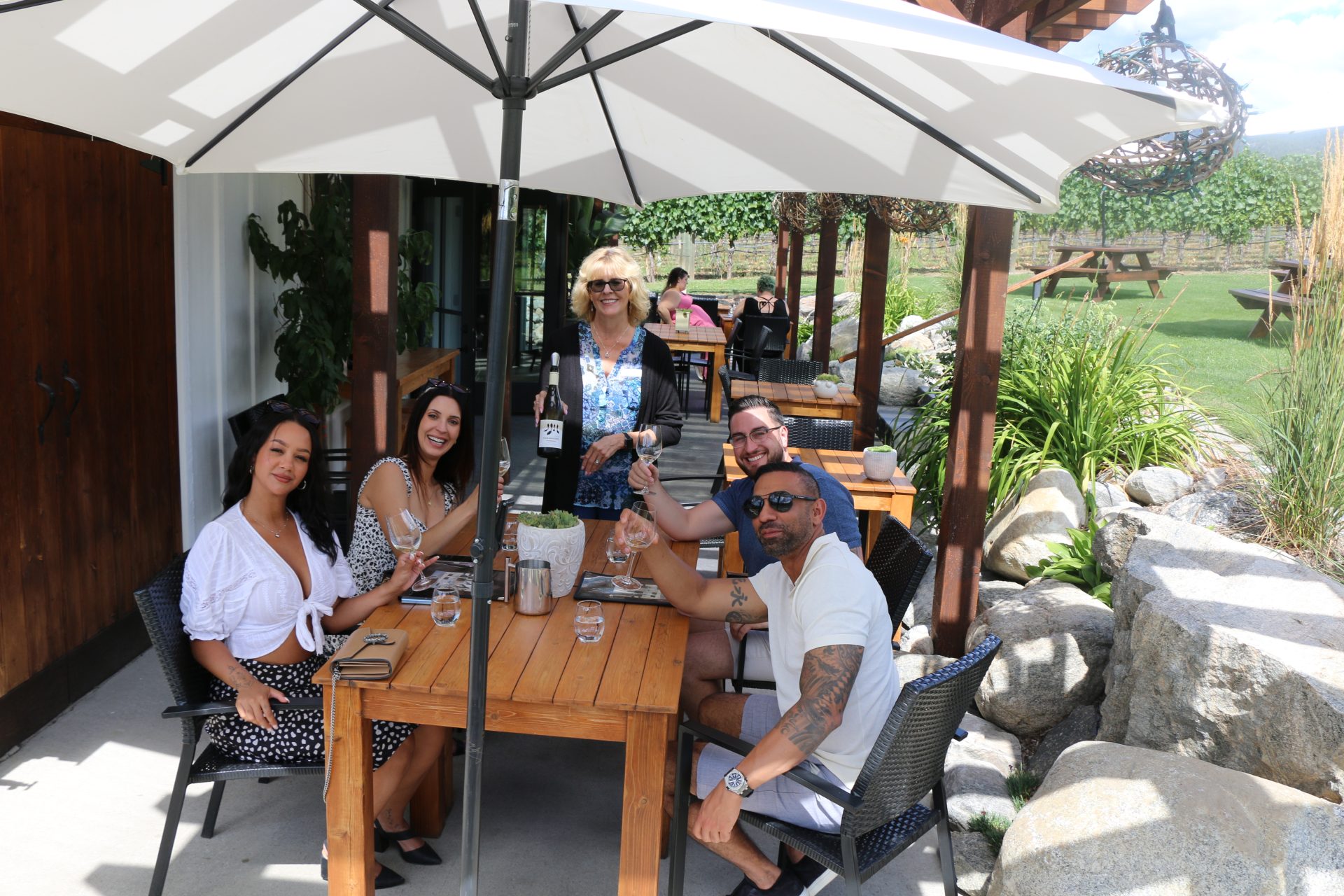 Bubbles Don't Guests enjoying vineyard side patio tasting at Four Shadows Winery.